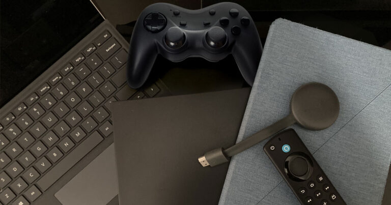 desk with game console controller and laptop